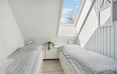 Duas camas num quarto com uma janela em Beautiful Apartment In Blokhus With Kitchen em Blokhus