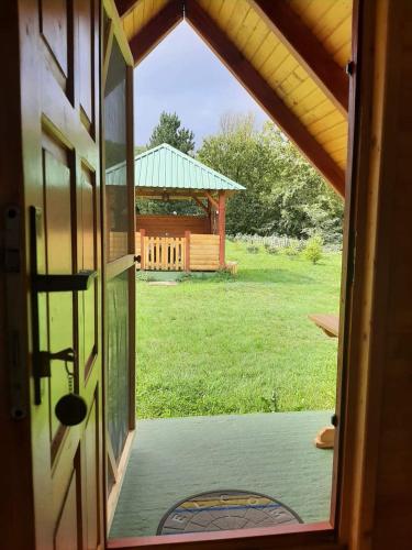 an open door of a house with a gazebo at Konaci Očeva Zemlja Vikendica i Bungalovi in Mojkovac