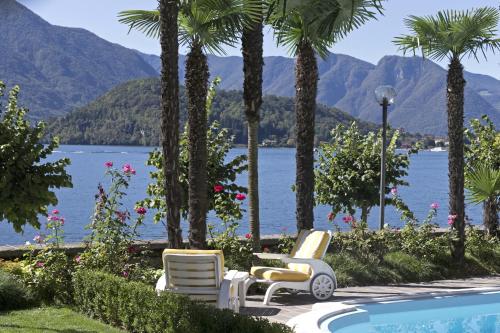 a group of chairs and a swimming pool with mountains at Hotel Villa Marie in Tremezzo
