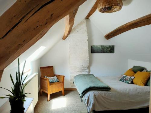 1 dormitorio con 1 cama y 1 silla en el ático en Le Cosy Sénonais, en Sens