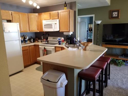 a kitchen with wooden cabinets and a white refrigerator at Lovely Mountain condo, remote workspace, 2 kayaks next to Lake Dillon in Frisco
