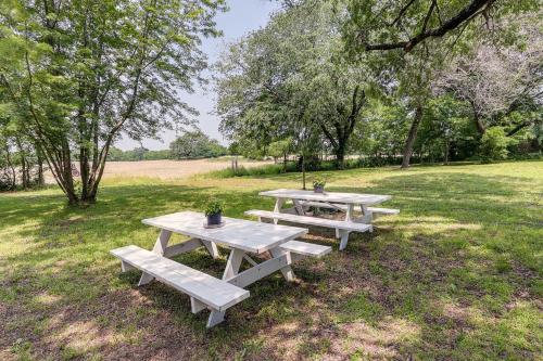 a group of picnic tables in a field at Coffeyville Countryside Studio with Fire Pit! in Coffeyville