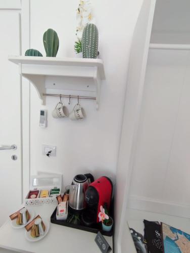a small kitchen with a shelf in a refrigerator at Siracusa Ortigia by Duomo in Siracusa