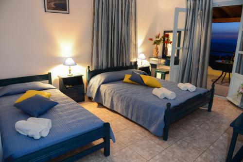 1 dormitorio con 2 camas y toallas. en Hotel Dina - Ξενοδοχείο Ντινα en Plati