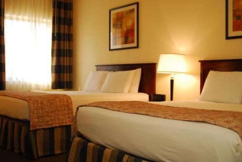 a hotel room with two beds and a window at Ramada by Wyndham Bettendorf in Bettendorf