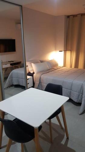 a room with two beds and a table and a mirror at Tucuman Premium Nuevo Estudio Mejor Zona de Rosario in Rosario