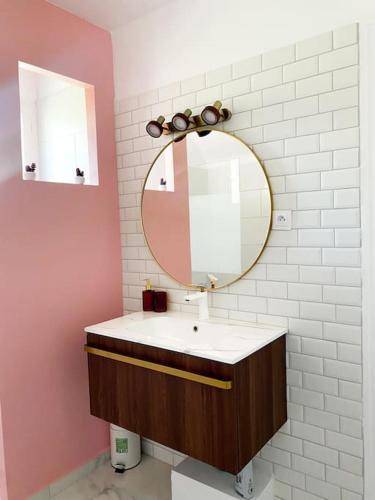 une salle de bain avec un lavabo et un miroir dans l'établissement #Maison de charme à Gargenville#, à Gargenville