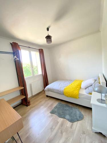 - une chambre avec un lit doté d'une couverture jaune et d'une fenêtre dans l'établissement #Maison de charme à Gargenville#, à Gargenville