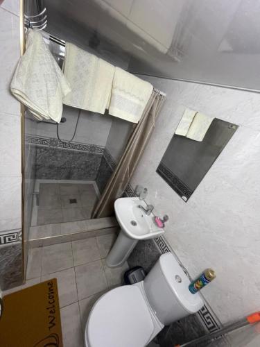 uma casa de banho com um WC branco e um lavatório. em Квартира дом в общем дворе em Samarkand