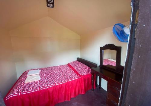 a bedroom with a red bed and a mirror at Napo Beach Resort in Maripipi