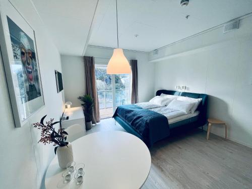 een slaapkamer met een bed en een witte tafel bij Lofoten Studio Penthouse in Svolvær