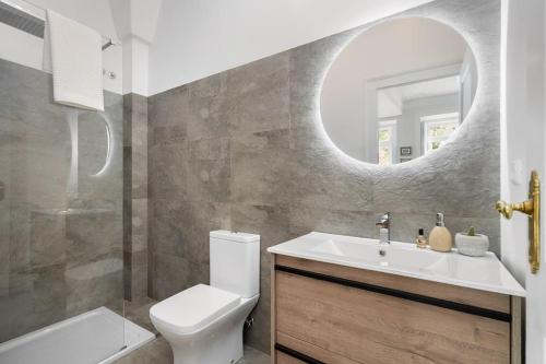 W łazience znajduje się umywalka, toaleta i lustro. w obiekcie Flat Art - Luxury with private Pool & Garden w Lizbonie