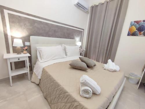 a bedroom with a large bed with a phone on it at Siracusa Ortigia by Duomo in Siracusa