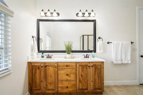 La salle de bains est pourvue d'un lavabo et d'un grand miroir. dans l'établissement A La Mode Stunning 4 bedroom Orem Home, à Orem