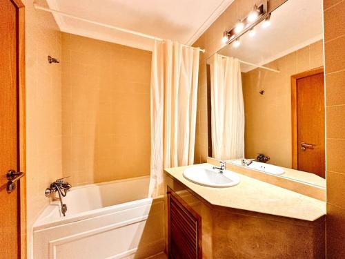 La salle de bains est pourvue d'un lavabo et d'une baignoire. dans l'établissement Sweety Bela Vista Apartment, à Lisbonne
