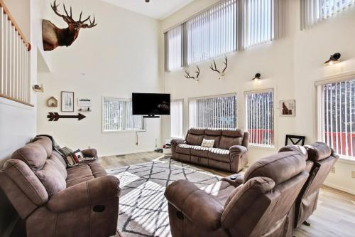a living room with two couches and a flat screen tv at Cascade Cabin Mountain Getaway with Private Beach in Cascade