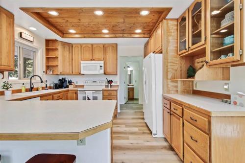 una cucina con armadi in legno e frigorifero bianco di Cascade Cabin Mountain Getaway with Private Beach a Cascade
