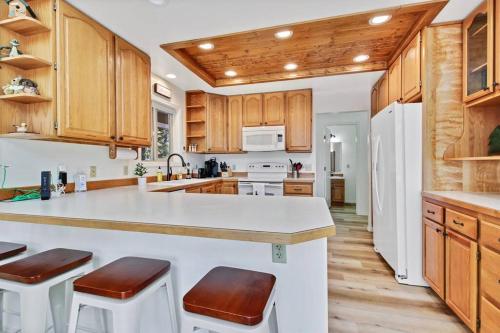 a kitchen with wooden cabinets and a white refrigerator at Cascade Cabin Mountain Getaway with Private Beach in Cascade