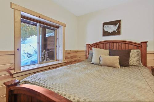 sypialnia z dużym łóżkiem i oknem w obiekcie Dreamy updated log cabin in the woods close to lak w mieście Cascade