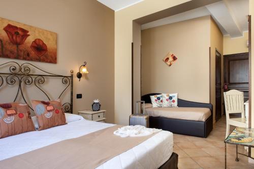 a bedroom with two beds and a chair at Il Giardino del Sol in San Vito lo Capo