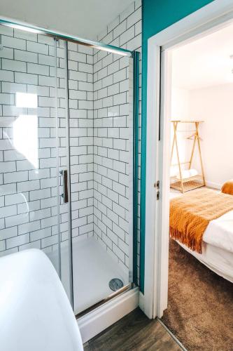 a glass shower in a bedroom with a bed at Principality View Apartment Two, by Solace Stays in Cardiff