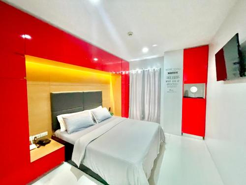 sypialnia z łóżkiem z czerwonymi i żółtymi ścianami w obiekcie Cityscape Residences 1102 w mieście Bacolod