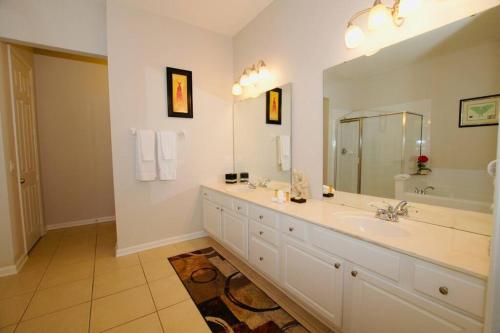 a bathroom with a sink and a large mirror at Vista Cay Luxury Loft in Orlando