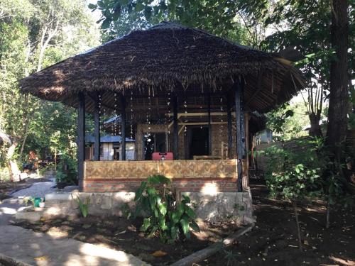 a small hut with a straw roof at Sunset Cottages in Hitokalak