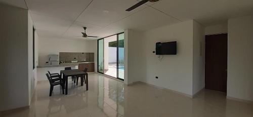 a dining room with a table and chairs and a television at VILLA SAMARI 4 Casa campestre con piscina privada in Girardot