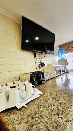 a room with chairs and a flat screen tv on a wall at Hostal Aires del Sur Centro de Rancagua in Rancagua