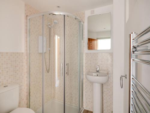 a bathroom with a shower and a toilet and a sink at Kingfisher Barn - Uk44098 in Carsington