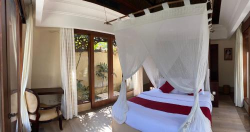 een slaapkamer met een hemelbed bij Jimbaran BeachStroll Villa (3BR) in Jimbaran