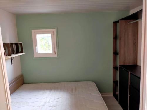 een slaapkamer met een bed en een raam bij Appartement en résidence avec parking in Le Barcarès