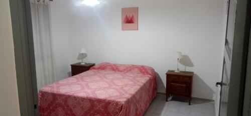 1 dormitorio con 1 cama roja y 2 mesitas de noche en Casa de Julia en Tunuyán