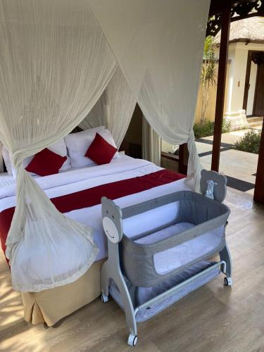 a bedroom with a bed with a mosquito net at Jimbaran BeachStroll Villa (3BR) in Jimbaran