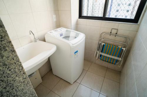 un piccolo bagno con lavatrice e lavandino di Golden Flat, apartamento mobiliado, em João Pessoa a João Pessoa