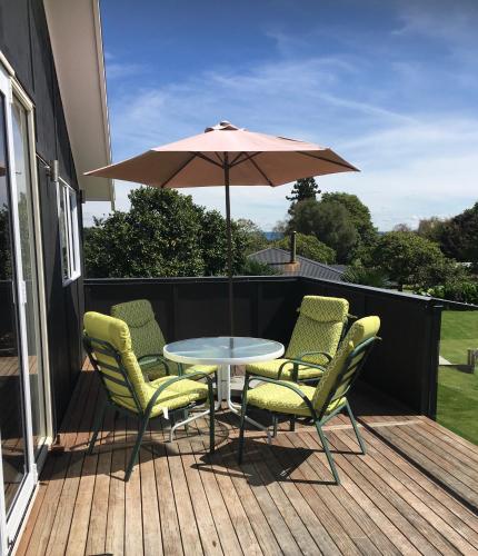 a table and chairs and an umbrella on a deck at Shearer's Quarters in Rotorua