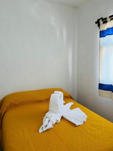 a pile of white towels sitting on a bed at Hostal Gautamas Guest rooms, hostal para viajeros,backpackers hostel in Tepoztlán