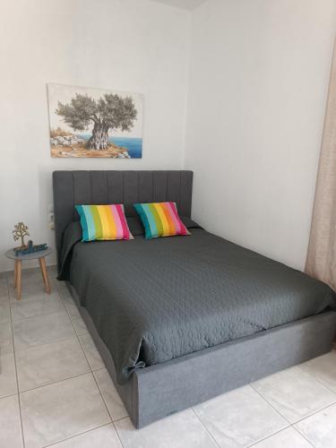 a bed with two colorful pillows in a bedroom at Maria Studios & Apartments in Kremasti