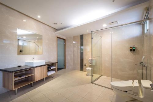 La salle de bains est pourvue de toilettes, d'un lavabo et d'une douche. dans l'établissement Xianghe Hotel, à Mingjian