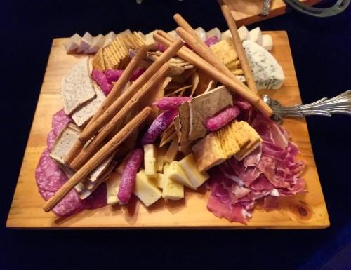 a wooden cutting board with different types of food on it at A Hotel Boutique Pelluhue in Pelluhue