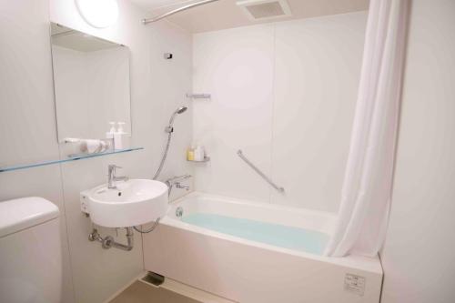 a bathroom with a tub and a sink and a shower at Shinjuku Miyabi Residence - Vacation STAY 94520 in Tokyo