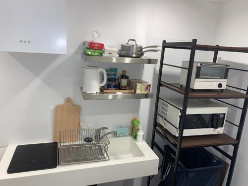 a kitchen counter with a sink and a shelf at Shinjuku Miyabi Residence - Vacation STAY 94520 in Tokyo