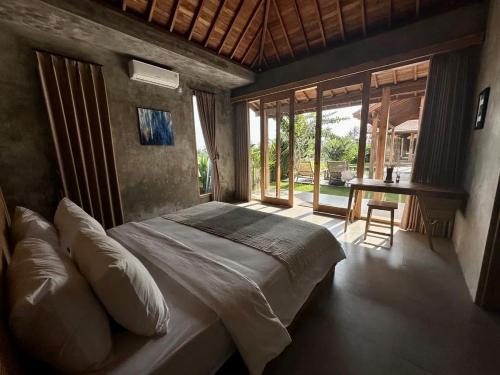 ein Schlafzimmer mit einem Bett und einem Schreibtisch. in der Unterkunft Bruann Villa 3 Pererenan, Seseh, Canggu, amazing view, 2 bedroom in Mengwi