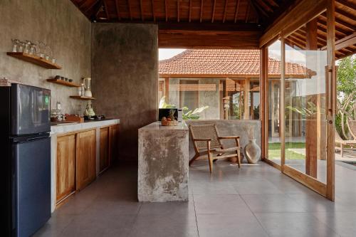 eine Küche mit einem Kühlschrank und einem Tisch mit einem Stuhl in der Unterkunft Bruann Villa 3 Pererenan, Seseh, Canggu, amazing view, 2 bedroom in Mengwi