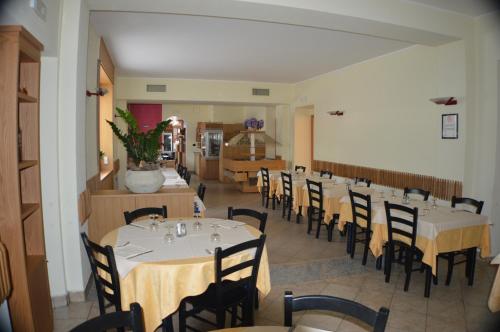 a dining room with tables and chairs in a restaurant at Sempione Hotel Malpensa in Casorate Sempione