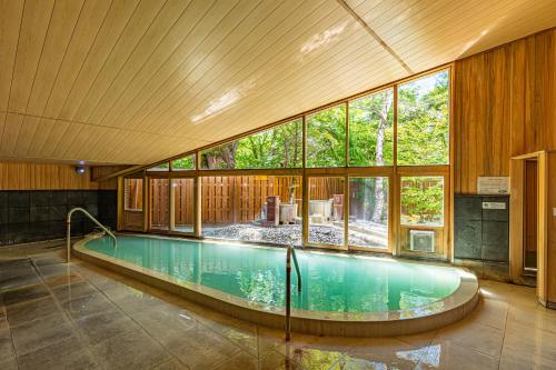 a swimming pool in a house with a large window at Kyukamura Nikko-Yumoto in Nikko