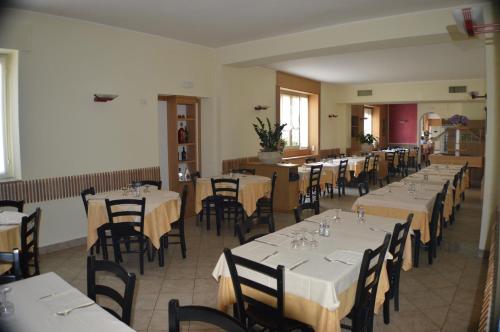 jadalnia ze stołami i krzesłami z białymi obrusami w obiekcie Sempione Hotel Malpensa w mieście Casorate Sempione