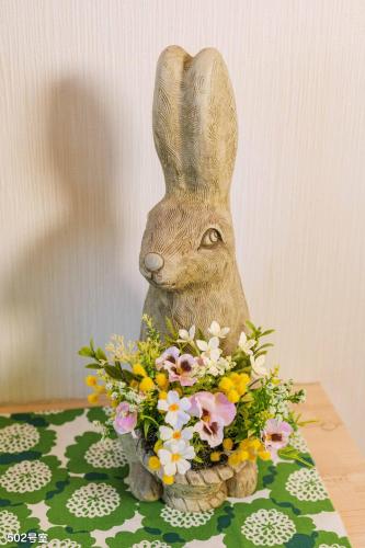 a statue of a rabbit holding a bouquet of flowers at NanEi Building in Kagoshima