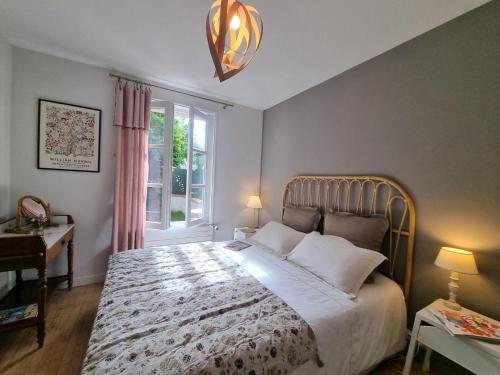 una camera da letto con un letto grande e una finestra di Gîte charmant avec jardin, terrasse et tout confort à Saint-Galmier - FR-1-496-293 a Saint-Galmier